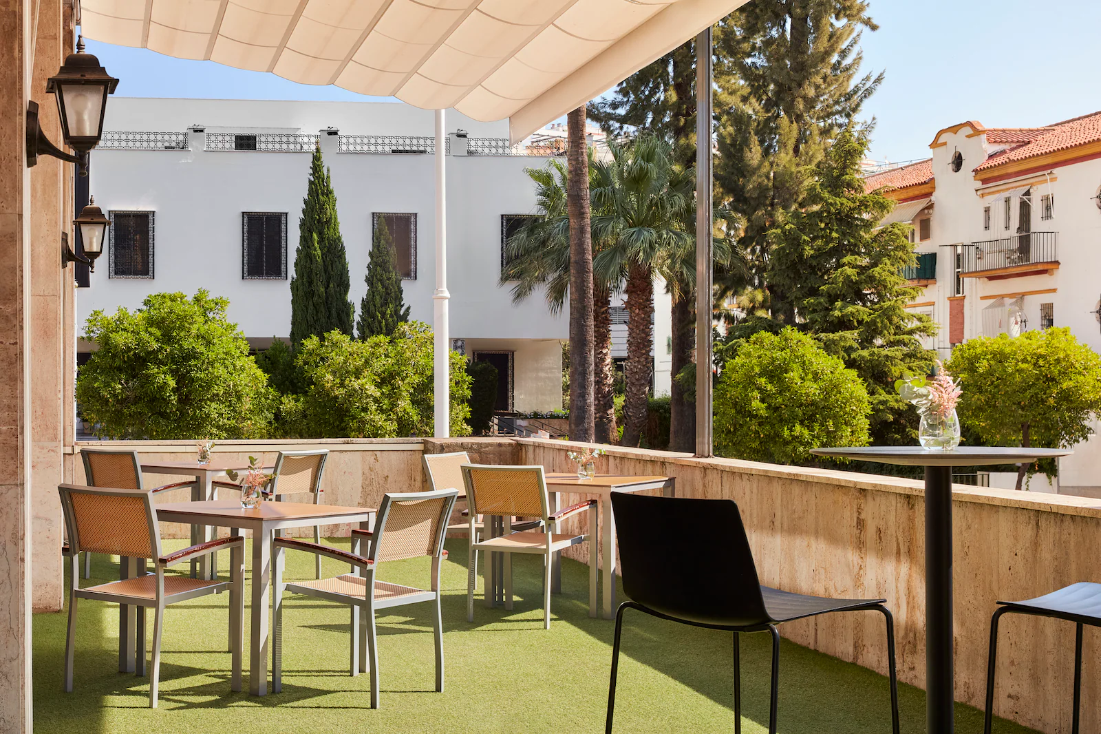 NH_Luz_Huelva_Bar_Terrace_Overview_Natural_Light_City_View_Vegetation_Tables_Chairs