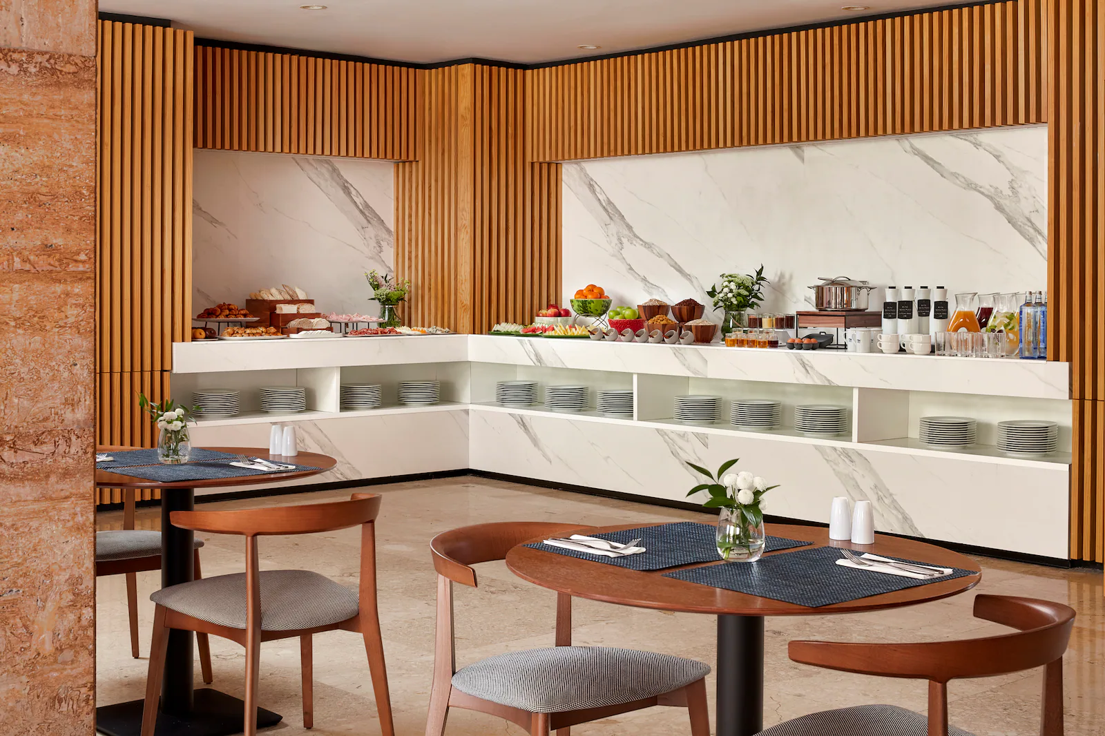 NH_Luz_Huelva_Buffet_Breakfast_Overview_Natural_Light_Food_Tables_Chairs_Flowers_Cutlary_Plates